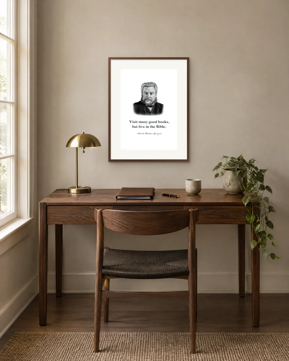 Charles Spurgeon quote print, “Visit many good books, but live in the Bible,” framed above a home office desk